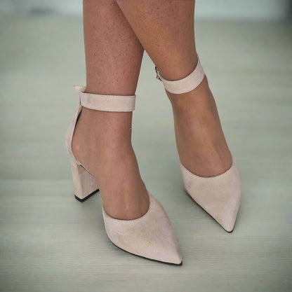 Woman wearing ankle strap court heels in nude suede