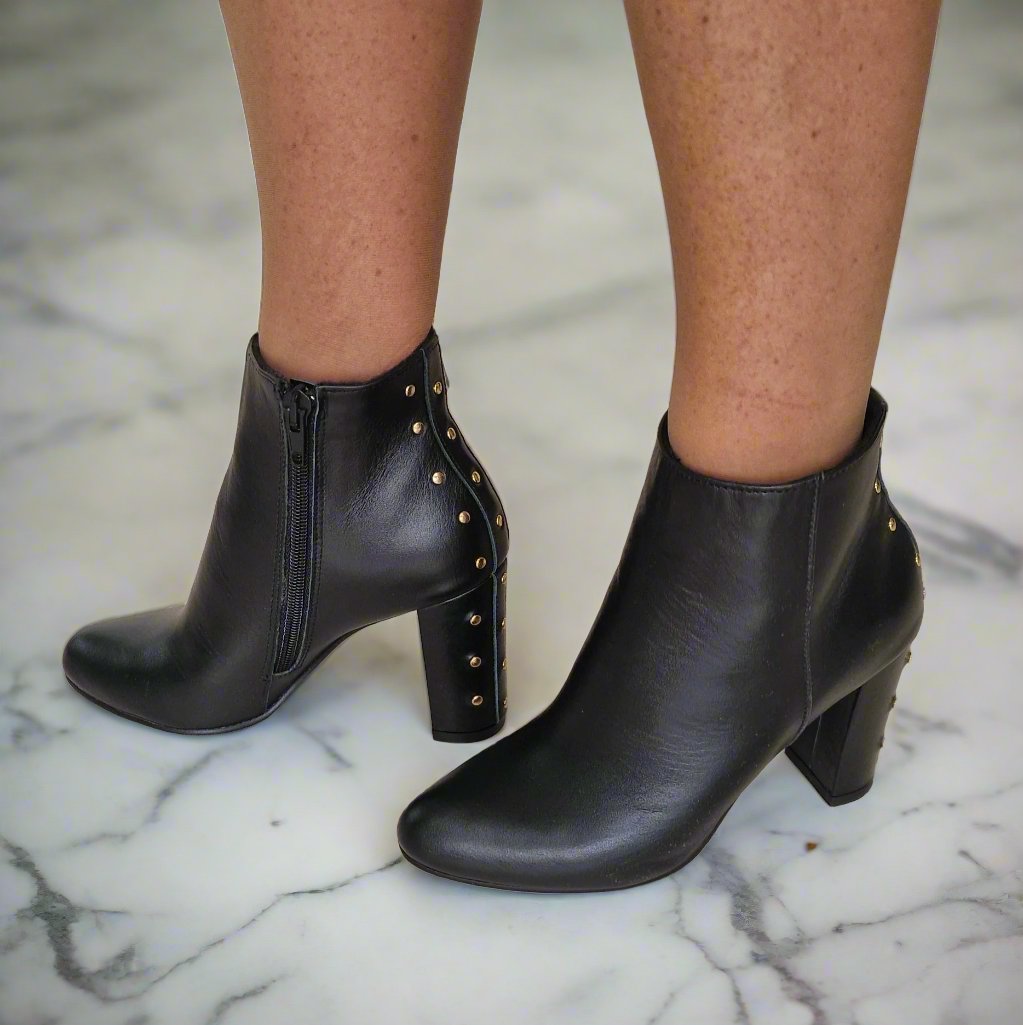 Woman wearing black leather boots with studs