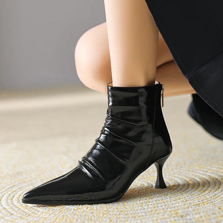 Woman wearing petite leather boots in black patent set on a kitten heel