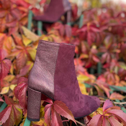 Petite ankle boots in burgundy surrounded by autumn leaves