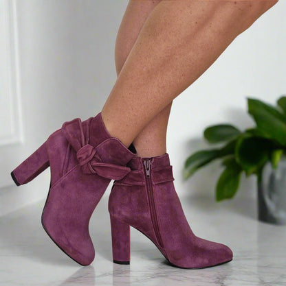 Woman wearing burgundy suede ankle boots