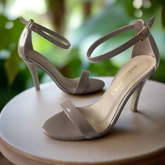 Elegant nude strappy high heels with ankle straps and stiletto heels, shown from a side and top view on a white background.