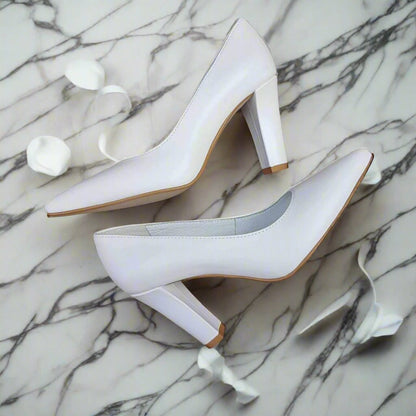 White leather wedding heels lying on a marble floor