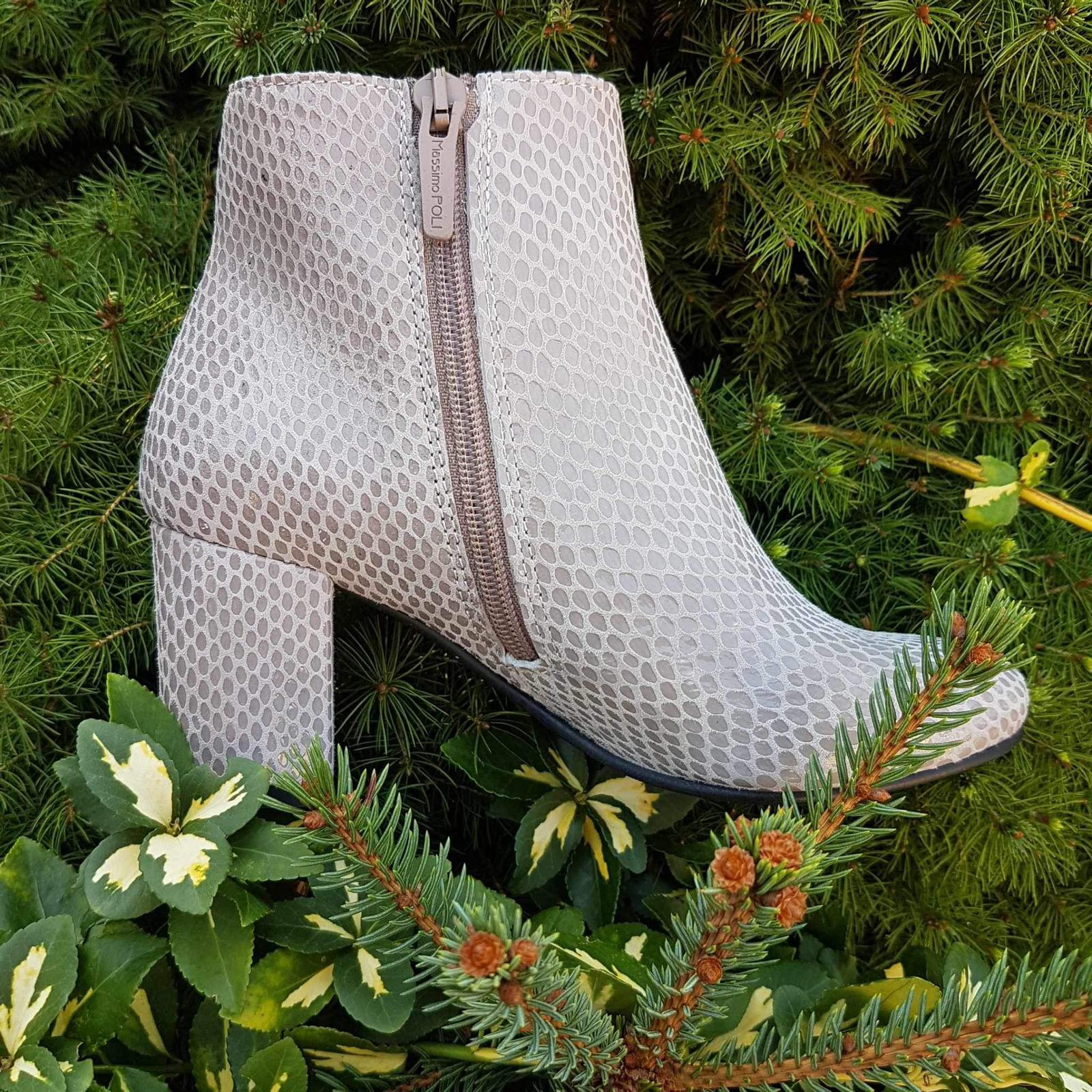 Grey leather ankle boots set against greet foliage 