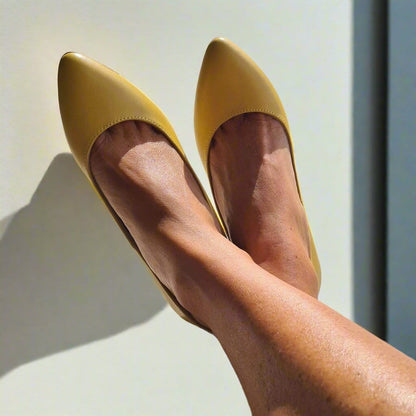 Woman wearing kitten heels in yellow leather