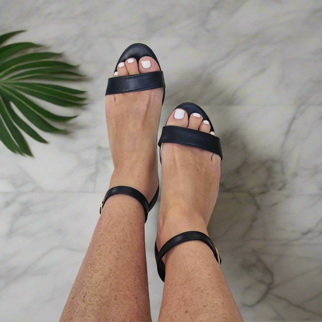 Woman wearing black simple strap sandals 