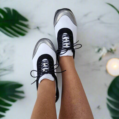 Woman wearing petite sneakers in white and black leather