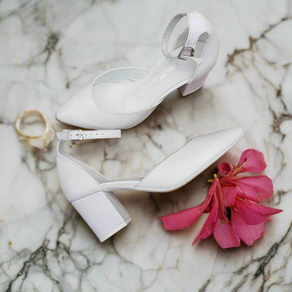 White leather wedding heels on a white marble floor