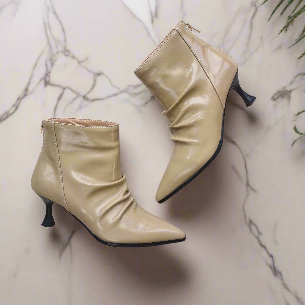 Beige leather ankle boots set on a black kitten heel