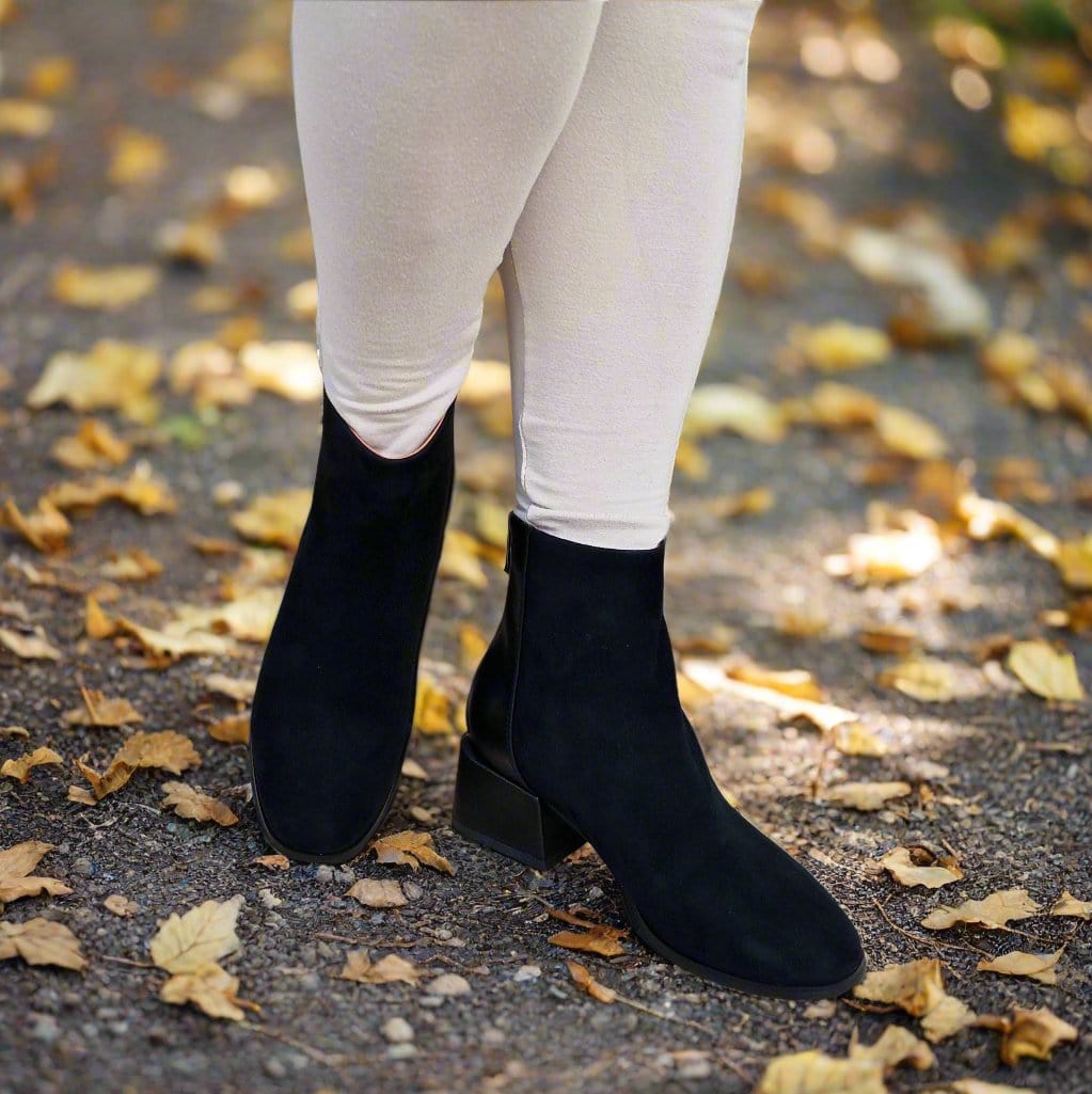 Woman walking in the park wearing cream leggings and petite black ankle boots