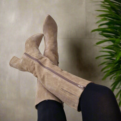 Woman wearing knee high suede boots in tan